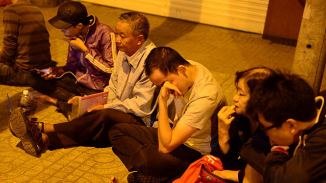 Sự mệt mỏi trên khuôn mặt của người dân phải ngồi đợi - Ảnh: Quang Định