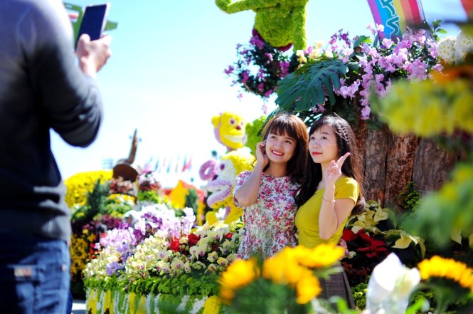 Nhờ bạn chụp hình trước một công trình đầy hoa - Ảnh: Lâm Thiên