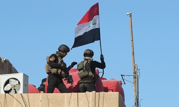 Binh sĩ cắm quốc kỳ Iraq lên nóc tòa nhà chính phủ ở Ramadi - Ảnh: AFP
