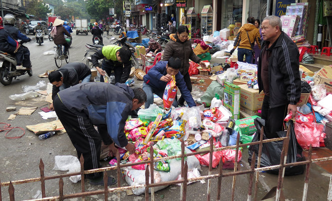 Tiểu thương thu dọn tài sản sau khi đưa từ vụ cháy ra ngoài - Ảnh: QUANG THẾ