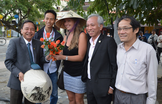 Ông Đinh Hài (bìa trái) cùng cán bộ TP Hội An chụp ảnh lưu niệm với 1 du khách nước Úc - Ảnh: Thanh Ba