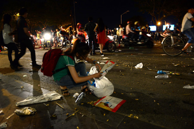 Một bạn nữ thu gom rác bị bỏ lại - Ảnh: Quang Định