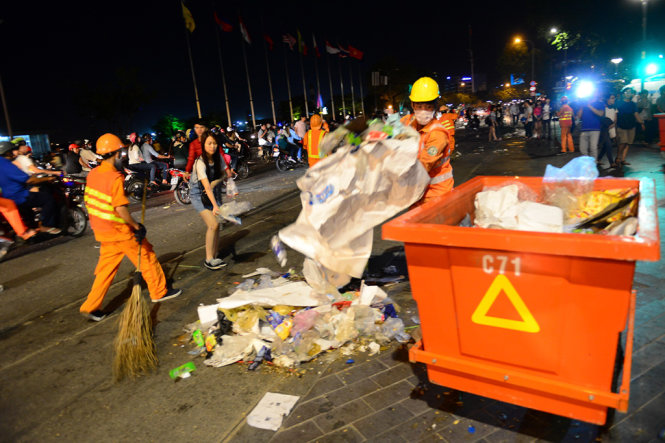 Công nhân vệ sinh dọn rác bị người dân bỏ lại - Ảnh: Quang Định