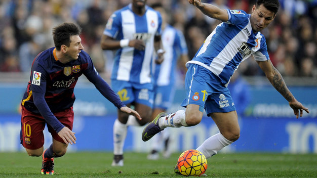 Messi (trái) té ngã trước sự truy cản của hậu vệ Espanyol - Ảnh: Reuters