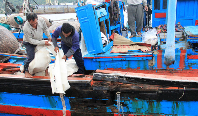 Ngư dân giúp nhau thu dọn ngư lưới cụ trên tàu bị nạn - Ảnh: TRƯỜNG TRUNG.