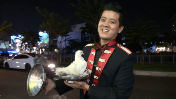 Nghệ sĩ đường phố Nguyễn Trường Giang biểu diễn tiết mục ảo thuật bồ câu