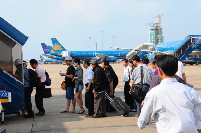 Hành khách đi máy bay VNA. Dù giá xăng giảm mạnh nhưng giá vé máy bay vẫn không chịu giảm - Ảnh: T.T.D.