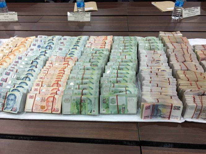 Số tiền mặt cảnh sát thu giữ từ hai nghi can - Ảnh: CNA