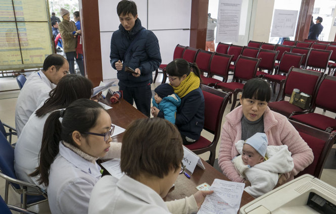 Các bậc phụ huynh đưa trẻ đi tiêm chủng tại Trung tâm Y tế dự phòng Nguyễn Chí Thanh (Hà Nội) - Ảnh: Việt Dũng