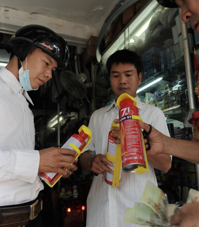 Một tài xế mua bình chữa cháy tại một cửa hàng trên đường An Dương Vương, Q.5, TP.HCM - Ảnh: Tự Trung