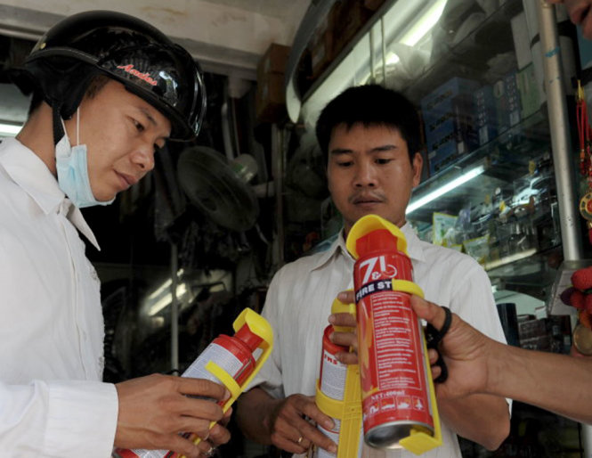 Một tài xế mua bình chữa cháy tại một cửa hàng trên đường An Dương Vương, Q.5, TP.HCM - Ảnh: Tự Trung