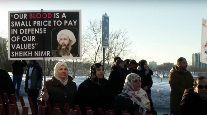 Người biểu tình giơ cao hình ảnh của giáo sĩ Hồi giáo dòng Shiite Nimr al-Nimr - Ảnh: Reuters