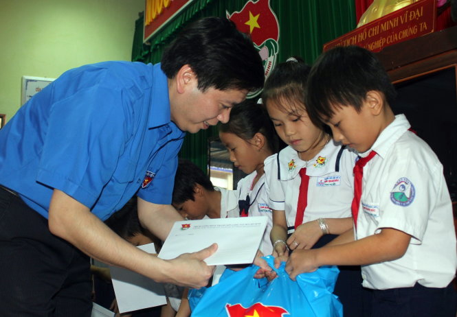 Bí thư Trung ương Đoàn Nguyễn Long Hải trao quà tết cho con em ngư dân nghèo học giỏi của huyện Hoài Nhơn - Ảnh: X.N.