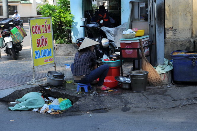 Quán cơm trên đường Ngô Thời Nhiệm Q.3, TP.HCM rửa chén bát ngay trên một hố ga đầy rác rất mất vệ sinh - Ảnh: Tự Trung