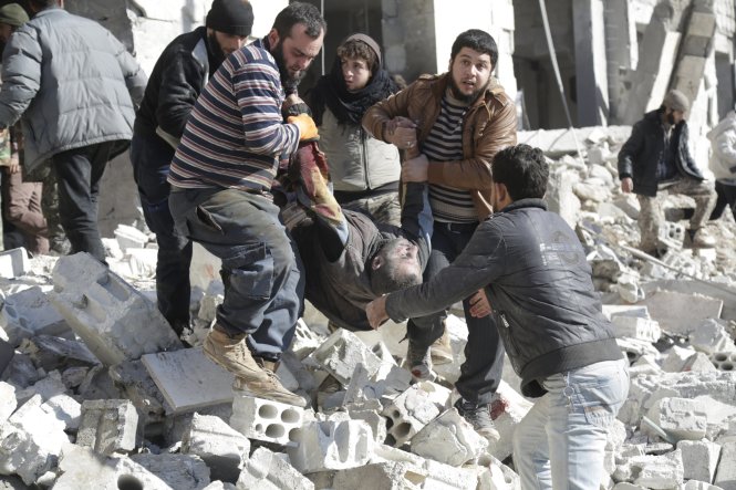 Người dân ở Idlib đưa một người bị thương ra khỏi đống đổ nát sau cuộc oanh tạc của Nga. Ảnh: Reuters