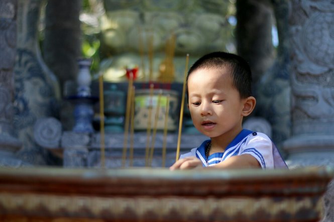 Cháu Nguyễn Quốc Duy (3 tuổi) theo mẹ lên chùa. Trẻ em trên đảo - Ảnh: Ngọc Hiển