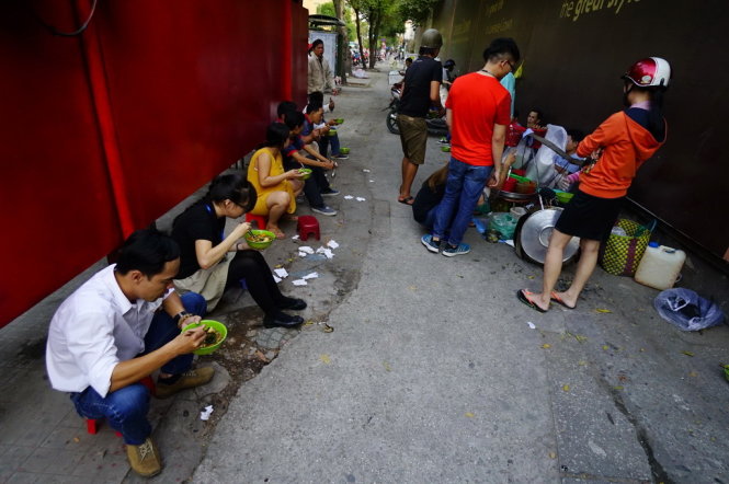 Nhiều người ngồi ăn canh bún trên vỉa hè đường Hai Bà Trưng, Q.1, TP.HCM, trong khi giấy vệ sinh được bỏ lại rất nhiều - Ảnh: Quang Định