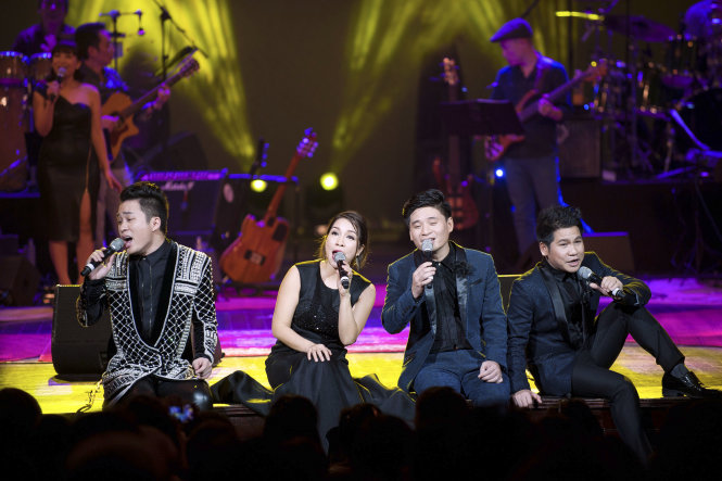 Bốn ca sĩ ngồi bệt xuống rìa sân khấu hát Lắng nghe mùa xuân về. Ảnh: Tú Nguyễn