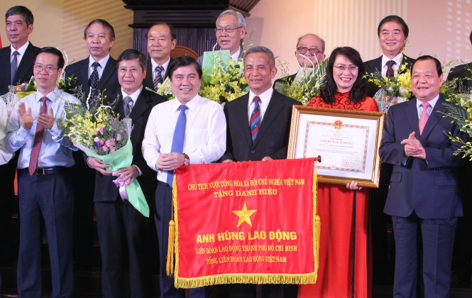 Ông Lê Thanh Hải - ủy viên Bộ Chính trị, chỉ đạo Đảng bộ TP.HCM 
(bìa phải) - trao tặng danh hiệu Anh hùng lao động cho Liên đoàn Lao động TP.HCM - Ảnh: Vũ Thủy