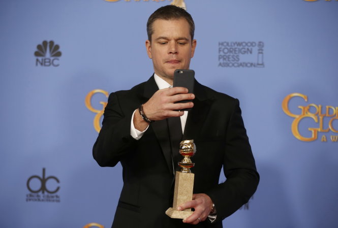 Matt Damon chụp ảnh “tự sướng” với tượng Quả cầu vàng - Ảnh: Reuters