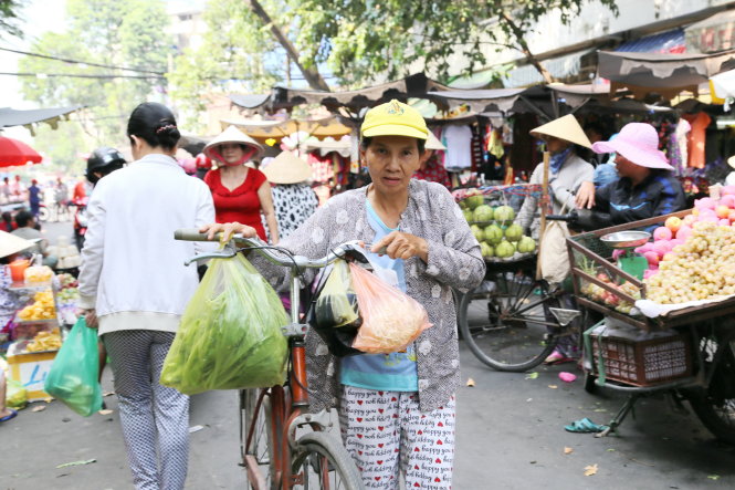 Nhiều người dân vẫn có thói quen sử dụng túi nilông khi đi chợ - Ảnh: Như Hùng