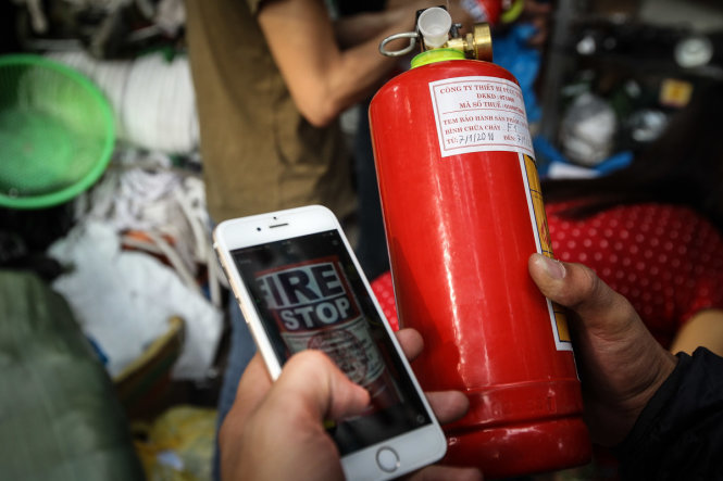 Một người dân phải kiểm tra lại giá bình chữa cháy trước khi mua - Ảnh Nguyễn Khánh