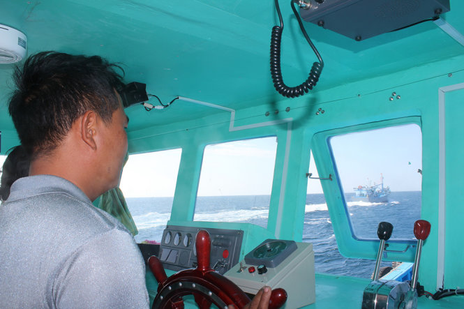 Tài công Nguyễn Thanh Chương đang điều khiển tàu cá Việt Anh theo sau tàu cá Kim Anh - Ảnh: Minh Trân