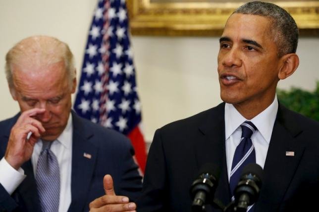 Tổng thống Mỹ Barack Obama (phải) đọc diễn văn trong khi ông Joe Biden đứng sau lắng nghe Ảnh: Reuters