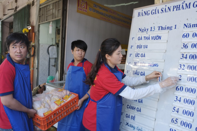 Nhân viên cửa hàng chi nhánh 2 Công ty chăn nuôi Long Bình, số 5 Nguyễn Thái Học, Q.1, TP.HCM niêm yết giá gà trong ngày (13-1) - Ảnh: Hoài Linh