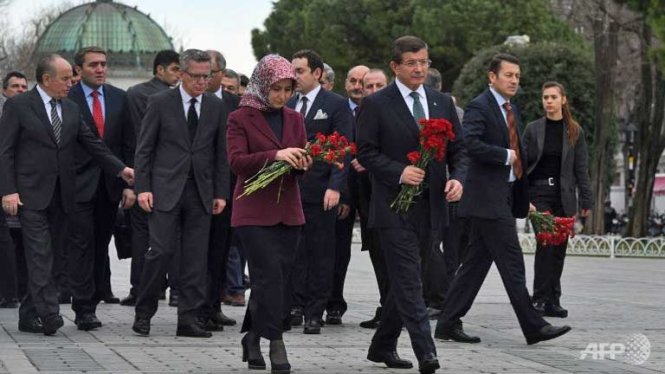 Thủ tướng Thổ Nhĩ Kỳ Ahmet Davutoglu  và phu nhân cùng Bộ trưởng nội vụ Đức Thomas de Maiziere  đến đặt hoa tưởng niệm các nạn nhân trong vụ đánh bom liều chết do IS thực hiện hôm 12-1 - Ảnh:AFP