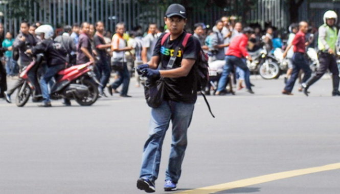Kẻ khủng bố Afif đang chĩa súng vào người đi trên đường Tharin ở Jakarta trước khi cho nổ bom liều chết- Ảnh: Tempo/Aditia Noviansyah