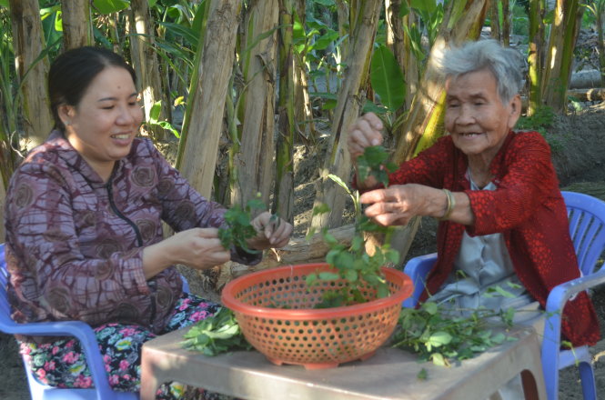 Chị Hùng cùng mẹ chồng chăm lo cho bữa ăn gia đình - Ảnh: Minh Tâm