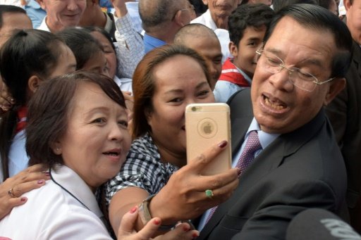 Thủ tướng Hun Sen thể hiện hình ảnh trẻ trung khi chụp selfie với dân chúng - Ảnh: AFP