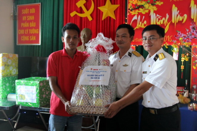 Trung tá Bùi Xuân Bổng (giữa) - chỉ huy trưởng nhà giàn DK1-9 - nhận quà tết của bạn đọc Tuổi Trẻ đóng góp - Ảnh: Đức Trong