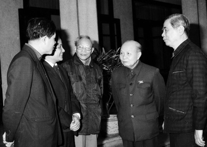 Ông Trường Chinh và ông Nguyễn Văn Linh trò chuyện với các thành viên trong ban soạn thảo văn kiện Đại hội VI, tháng 11-1986 - Ảnh: Xuân Lâm