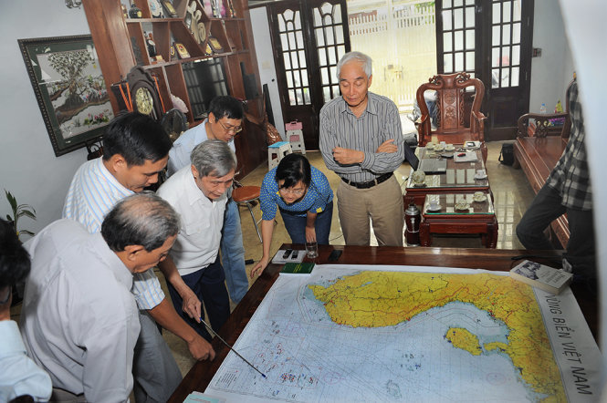 Chuẩn đô đốc Lê Kế Lâm, nguyên phó tham mưu trưởng Quân chủng hải quân Việt Nam (cầm gậy), trao đổi với các vị khách mời bên tấm bản đồ vùng biển Việt Nam - Ảnh: Tự Trung