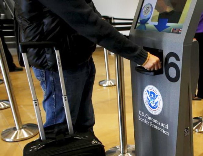 Một người du lịch đến Mỹ đang quét hộ chiếu - Ảnh: Reuters