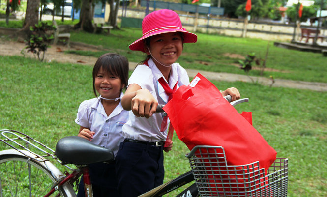 Nụ cười rạng rỡ của hai chị em đang theo học tại Trường tiểu học Lê Phong khi được nhận quà từ chương trình Cây mùa xuân cho trẻ em nghèo - Ảnh: PHAN THÀNH