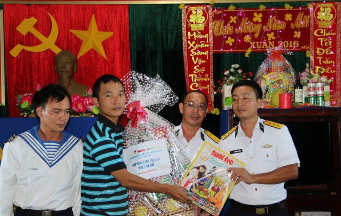 Phóng viên báo Tuổi Trẻ (thứ 2 từ trái) tặng quà và giai phẩm xuân Bính Thân 2016 của báo tuổi Trẻ cho đại diện nhà giàn DK1/10. Ảnh: Thái Lộc