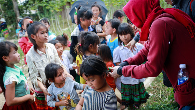 Thành viên nhóm từ thiện cột tóc cho em nhỏ thôn Giang Đông - Ảnh: Tiến Thành