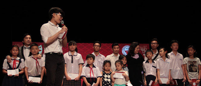 NSND Kim Cương (mặc áo dài đen ở giữa) và NSUT Kim Tử Long (đứng thứ 2 từ bên trái) trao qua cho con em nghệ sĩ nghèo hiếu học - Ảnh: Nguyễn Lộc