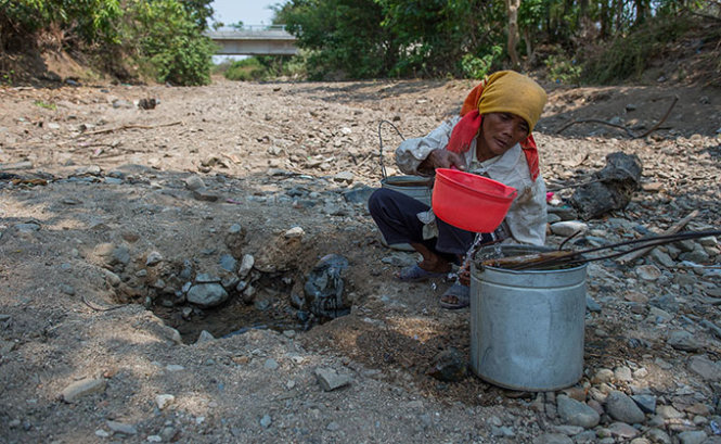 Một phụ nữ chắt những giọt nước sạch từ hố đào giữa con suối đã cạn đáy ở xã Phước Trung, huyện Bác Ái, tỉnh Ninh Thuận trong đợt hạn hán tháng 5-2015 - Ảnh: Thuận Thắng
