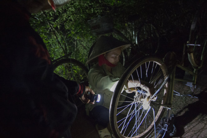 Cô Nguyễn Thị Dung tranh thủ sửa xe đạp trước khi xe tải tới chở đá vào lúc 5g sáng. Các bãi đá cách xa nhau mà một ngày có khi các cô phải chạy qua chạy lại nhiều lần
