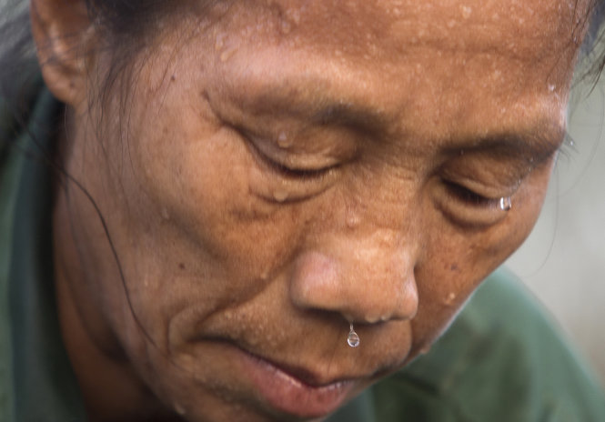 Mồ hôi đua nhau nhỏ từng giọt trên khuôn mặt cô Đỗ Thị Sợi (57 tuổi). Cô có 26 năm làm nghề này