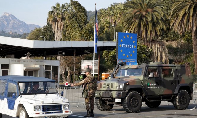 Viên cảnh sát đang chặn một chiếc ô tô ở biên giới Pháp – Italy ngày 24-1 - Ảnh: Reuters