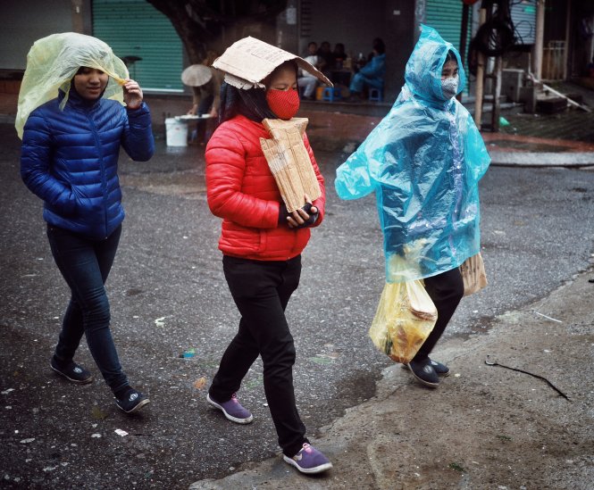 Lao động nữ ngoại tỉnh đang dùng tất cả các vật như áo mưa mảnh bìa để che lạnh