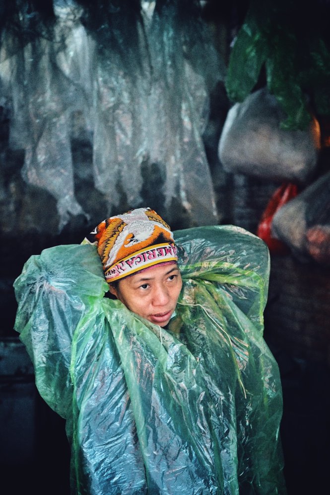 Một chị công nhân môi trường đang gia cố thêm tấm áo mưa tránh rét.