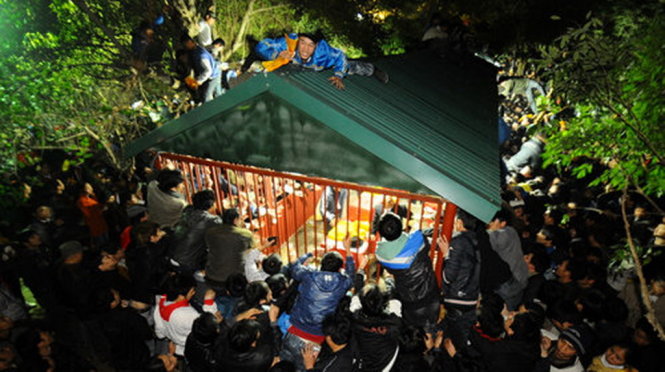 Hàng ngàn người bao vây một trong các điểm bán ấn tại lễ khai ấn đền Trần (Nam Định) đêm 16-2 - Ảnh: Thuận Thắng