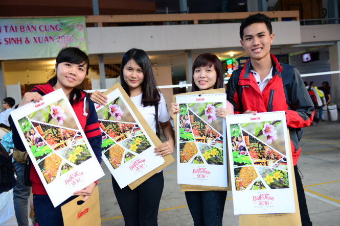 Một nhóm bạn sinh viên tươi cười khi nhận được những tờ lịch của báo Tuổi Trẻ trao tặng miễn phí - Ảnh: Quang Định