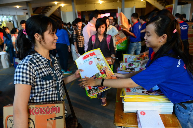 Các bạn sinh viên đón tết xa nhà được tặng báo Tuổi Trẻ xuân miễn phí được phát tại chương trình - Ảnh: Quang Định